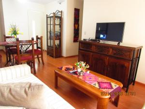 a living room with a couch and a tv at Bonito Apartamento en Miraflores in Lima