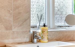 a bathroom sink with a bottle of sunscreen on it at Lorash Cottage, Ashbourne in Ashbourne +13 photos