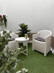 two chairs and a table in a room with plants at Centrale Suites in Brindisi