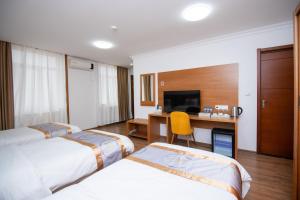a hotel room with two beds and a desk at Fude Hotel T bilis第比利斯富德酒店 in Tbilisi City