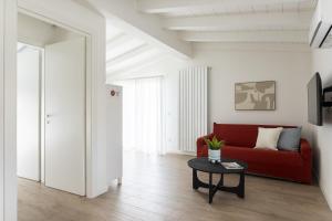 a living room with a red couch and a table at Maison Bellini number 3 in Toscolano Maderno