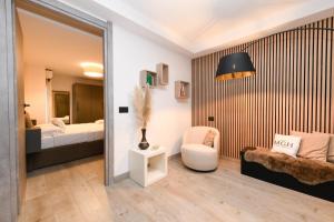 a room with a bed and a chair and a mirror at MGH Luxury- Romantic SPA & Relax in Poiano +47 photos