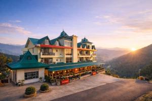 a hotel in the mountains with the sun setting at The Hamilton Valley View, Koti - A Beautiful Resort in Cloud's in Shimla