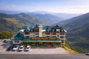 a hotel with cars parked in a parking lot at The Hamilton Valley View, Koti - A Beautiful Resort in Cloud's in Shimla