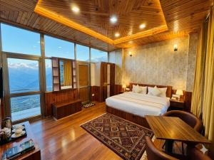 a bedroom with a bed in a room with large windows at The Hamilton Valley View, Koti - A Beautiful Resort in Cloud's in Shimla