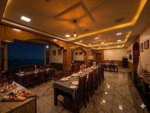 a dining room with a long table and chairs at The Hamilton Valley View, Koti - A Beautiful Resort in Cloud's in Shimla