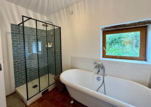a bathroom with a bath tub and a window at Authentic house, absolutely quiet in Coust +26 photos