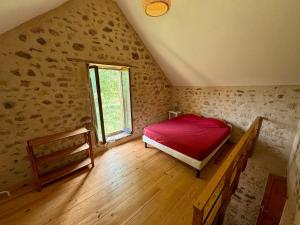 a bedroom with a red bed and a window at Authentic house, absolutely quiet in Coust
