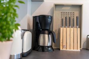 a coffee maker sitting on a counter next to a box at Haus an der Koppel in Borgsum