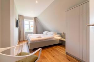 a small bedroom with a bed and a window at Haus an der Koppel in Borgsum