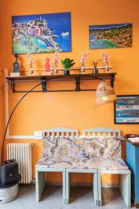 a living room with a bench and shelves on the wall at Ostello Tramonti in Biassa