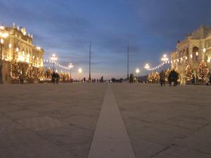 een groot plein met kerstbomen voor een gebouw bij Mansarda 23 in Trieste