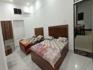 a bedroom with two beds in a room at Hotel Maa Karni Darbar in Deshnoke