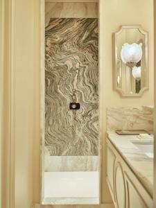 a bathroom with a marble shower with a mirror at Hôtel Aventure in Paris