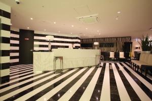 神戸市にあるセンチュリオンホテル神戸駅前の黒と白のストライプフロアのロビー