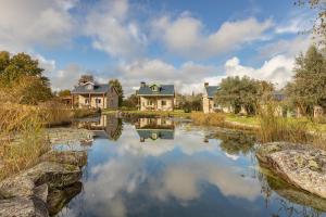 a home with a pond in front of some houses at Chão do Rio - Turismo de Aldeia - Serra da Estrela in Seia