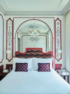 a bedroom with a large white bed with a red headboard at Hôtel Aventure in Paris