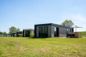 a modern house with a grassy yard at Vakantiepark Lemmer in Lemmer