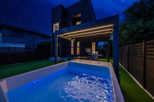 a hot tub in the backyard of a house at night at Galaxy Pool Resort in Takashima +11 photos