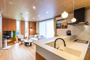 a kitchen with a sink and a living room at Galaxy Pool Resort in Takashima