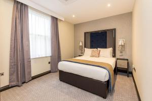 a bedroom with a large bed and a large window at The Westbourne Residences in London