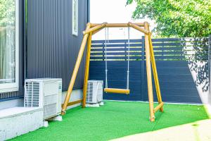 a swing set on the side of a house at Galaxy Pool Resort in Takashima