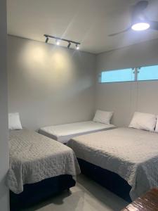 a room with two beds and a window at Lua Nova Studio II in Caraguatatuba