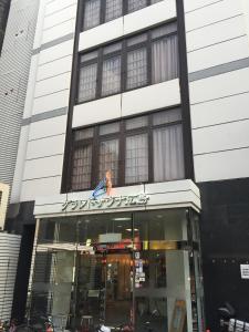 una tienda frente a un edificio con un cartel. en Capsule&Spa Grand Sauna Hiroshima (Male Only) en Hiroshima