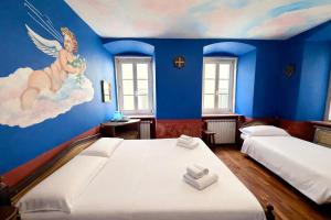 a bedroom with two beds and a painting on the wall at Hotel Portacavana in Trieste