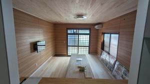 a room with wood paneling and a large window at お宿&カフェバーもか in Higashikagawa