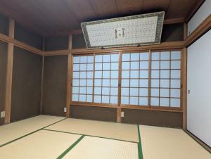 a room with a large window and a chandelier at お宿&カフェバーもか in Higashikagawa