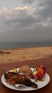a plate of food on a table near the beach at Heaven Dune Camp in Nuweiba