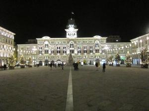 un gran edificio con árboles de Navidad delante de él en Studio 23, en Trieste
