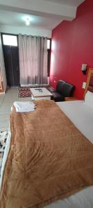 a large bed in a room with a red wall at Woodward 2 by 4 Wildflower in Kasol