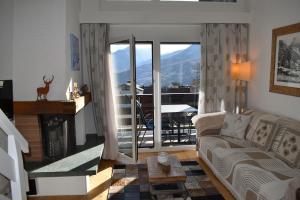 a living room with a couch and a fireplace and a balcony at Ferienwohnung Caluna in Lenz