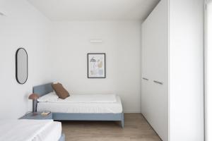 a white bedroom with a bed and a closet at Maison Bellini 1 in Toscolano Maderno