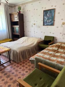 a bedroom with two beds and a couch and a chair at Garabuczi Apartman in Keszthely