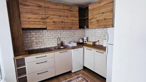 a kitchen with white cabinets and a white refrigerator at HTH Apartments in Center of Gjakova - 4th Floor in Gjakove