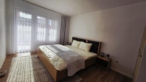 a bedroom with a bed and a large window at HTH Apartments in Center of Gjakova - 4th Floor in Gjakove