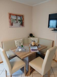 a dining room table with chairs and a television at Ferienwohnung May in Seiwerath