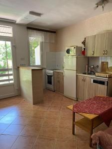 a kitchen with a refrigerator and a table in it at Garabuczi Apartman in Keszthely