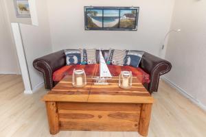 a living room with a couch and a coffee table at Hundeparadies "Bodden Paradise Cottage" in Pruchten