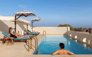 a boy sitting in a swimming pool at a resort at Gulab Haveli - IHCL SeleQtions, Mandawa in Mandāwa