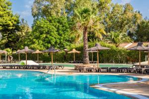a swimming pool with tables and umbrellas and chairs at 4 Mori Family Village - Villaggio per Famiglie in Muravera
