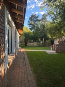 a porch of a house with a bench on the grass at Kubbe Comfort Corner in Bloemfontein