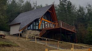 a large house with a gambrel roof and a deck at Gonta house in Skhidnitsa