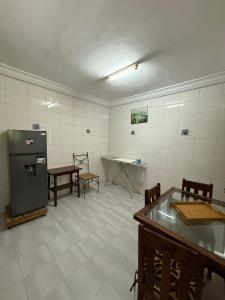 a kitchen with a refrigerator and a table in it at Providence Guesthouse and Catering Services in Abidjan