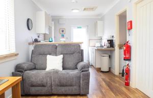 a living room with a chair with a pillow at Skeabost View Chalet in Portree