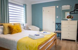 a bedroom with a bed with towels on it at Skeabost View Chalet in Portree