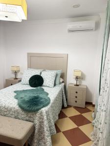 a bedroom with a bed with a green pillow on it at Casa Miguelín in Montecorto